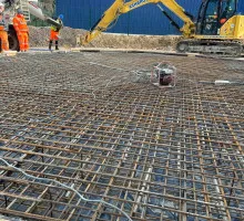 Workers pouring concrete into newly built formwork